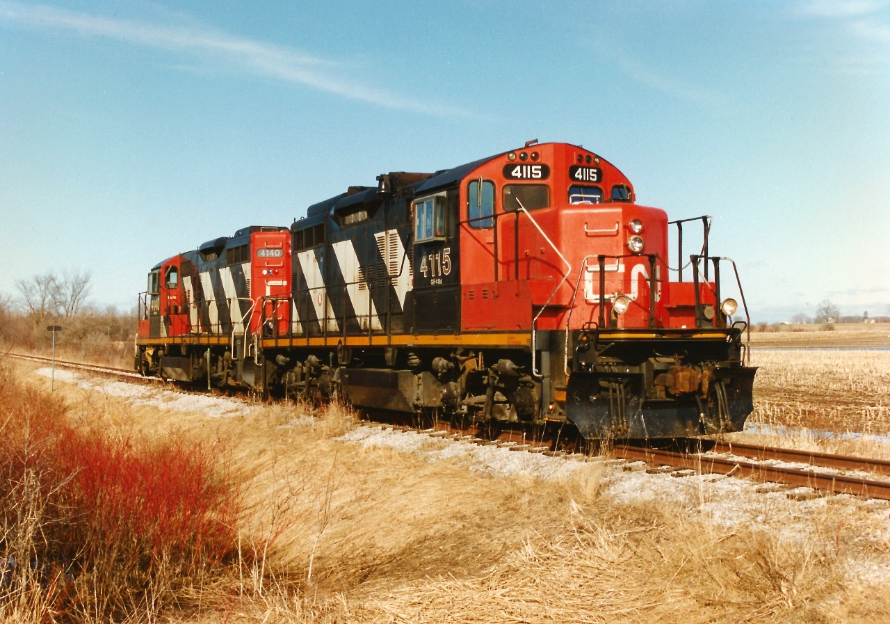 The power for the CN rail salvage train is viewed tied down for the night at Line 60, which was the first crossing west of Palmerston on the CN Newton Subdivision. The crew had uncoupled from the rail train several miles back and pulled the power up to the crossing where they would be picked-up and driven back to Stratford. The following day, CN GP9RM's 4115 and 4140 would return to the rail train cars and continue the assignment of taking-up the line towards Listowel. During April 1996, CN had removed the last sections of the Newton and Owen Sound Subdivisions that remained between Harriston and Stratford.