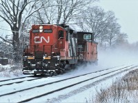 CN 4533 has a van hop up to track speed just east of Clarkson, Ontario and a cold January 1985 afternoon.  