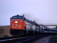 Drumming in the distance suggested that CLC-FM's were on CN Train 55, the Lakeshore.  Sure enough, not one but two CLC passenger units were in charge of the Montreal - Toronto train on the evening of Monday, August 21, 1967, just east of the station at Marysville, Ontario.  Marysville is at Mileage 207 of the Kingston Sub while the train is passing under Kings Highway 2.  The trailing units were CPB16-5 6804 and MLW FPA-2u 6759.  Train 55, the Bonaventure, was due at Belleville, Mileage 220.7, at 7.15 p.m., having left Montreal at 3.35 p.m. and, the previous stop, Kingston at 6.28 p.m.  It was due in Toronto at 9.20 p.m.  The Bonaventure was one of five daily Montreal - Toronto trains in the busy Centennial Year that attracted world-wide visitors to the Expo 67 World's Fair site in Montreal. <br> <br>  

CPA-16-5 6703 was part of six A-B sets purchased by the CNR from the Canadian Locomotive Company in nearby Kingston.  A pair of CPA24-5s, 4801 and 4802, toured the CNR beginning in August 1950 as Fairbanks Morse started its effective control of CLC.  (After the tour, FM sold the demonstrators as New Haven 790 and 791.)  Although GMD and MLW also provided demonstrators around this time, no order was forthcoming from the CNR for passenger units until 1954.  CLC was modestly successful in selling units to both Canadian National and Canadian Pacific.  Amongst other models, the CNR took sixty 1200hp roadswitchers between 1951 and 1956 while the CPR bought fifty H16-44s.   CLC delivered the 6703 in early 1955, and it became the last active CLC cab unit on CN when it was retired in May 1969. 