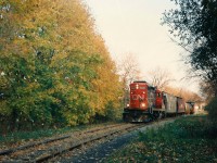 The CN 15:30 Job with GP9RM 7037 is crossing Allen Street in Waterloo as it heads north to Elmira on the Waterloo Spur with four cars and caboose 79883. The fall colors were always vibrant on the trees beside this section of track that was not far from Uptown Waterloo.