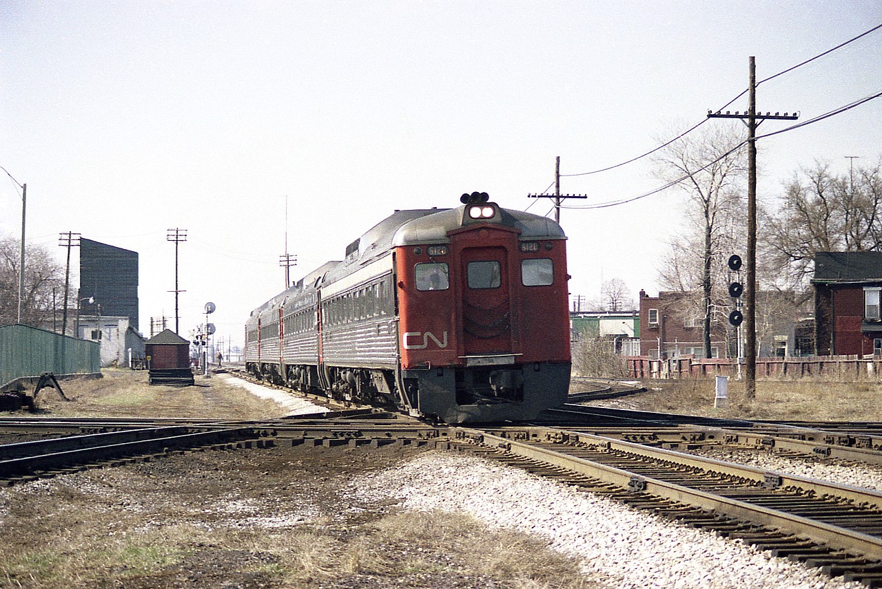 I cannot imagine what this area looks like today; as I have not been to the location of the old West Toronto diamond in years. But in 1977 it seemed quiet and simple. One could park the car and wander. And I did just that this April 10th, a pleasant Sunday.  Coming from London-way and heading into Toronto Union are the 'noon' Budds; CN 6120, 6006, 6115 and 6203; rolling on the CN Weston Sub where it crosses the CP North Toronto sub which is further complicated by the CP MacTier sub as it meanders from left to right heading northward in this photo. In the background behind the train is the CN West Toronto Station out by Weston Road crossing. Signals at right are for the CP service track.
