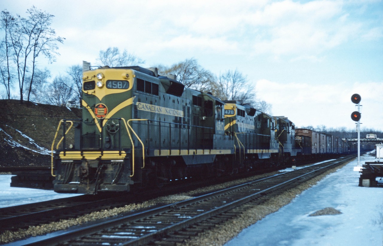 CN GP9 4587 leads two sisters (4478 and an unidentified unit) through Bayview during the winter of 1960. While I don't have a record of the train number, this may have been 463 which was due to leave Mimico at 1:00 PM in the early 1960s, with an 8:00 PM daily arrival in Fort Erie. (Trains 465, 463, and 305 also ran between Mimico and Fort Erie--departing Mimico at 12:15 AM (6:45 AM arrival), 4:45 AM (11:00 AM arrival), and 8:00 AM (1:30 PM arrival, Tuesday-Saturday). In addition, Train 461 to Niagara Falls departed Mimico at 11;45 PM and arrived Niagara Falls at 3:00 AM, daily except Sunday. Trains 482 and 484 departed Sarnia for Niagara Falls at 9:15 PM (3:30 AM arrival) and 8:45 AM (3:00 PM arrival)...so with counterparts in the opposite direction, there was lots of freight traffic on the Grimsby sub back then! (Plus daily trains 486 and 488 between Sarnia and Fort Erie via Canfield and the Dunnville sub!)
