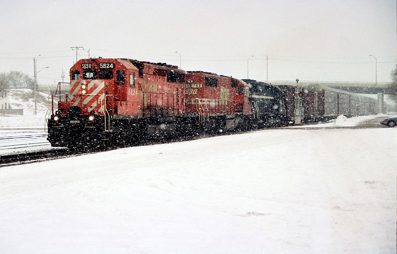 A CP westbound departs Galt, Ontario in a blinding snow squall after lifting two boxcars in the yard. The consist included; CP 5624, SOO Line 758 and an unidentified HLCX leaser.