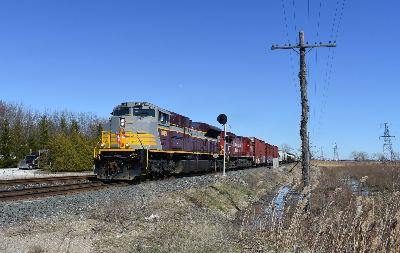 A freshly painted CP 7018 leads 235 around the curve at Tilbury and through the points of East siding switch Tilbury on it's way West towards Oak in Detroit.