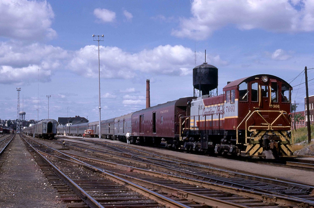 At 11.10 a.m., Sunday, August 20, 1957, the eastbound Canadian, Train 2, rolled into town behind units 1406, 8567 and 1407.  The schedule allowed thirty-five minutes for the splitting of the train into sections for Montreal and Toronto.  They would depart on time with 1407 removed from the consist of Train 2 with FPA-2 4083 and RS-10 8561 leading Train 12 to Toronto.  All units were steam generator equipped.  1407 would turn back west on the next Train 1 at 12.10 a.m. the following morning.  

With the power pulled well east of the station, S-2 7091 (MLW 2-1949 #75866) went to work.  Train 2 had arrived on the track closest to the station and the crew would rebuild it there.  Train 12 would be readied for departure on the adjacent track.  The usual three lightweight head-end cars, including two dormitory baggage cars, arrived on Train 2.   Each outbound train had one dorm, and 7091 added a car behind the power on Train 2 and two behind the power on Train 12.  Meanwhile, either 7090 or 7092 worked the other end of the Canadian.      

Using the line numbers from the CPR's folder 62-28, the S-2 marshalled the following equipment into each train.  The Toronto section included Sudbury - Toronto coach 223, coach 221 from Vancouver, Skyline cafe dome 222 from Sudbury.  The following cars came from Vancouver:  Manor cars 213, 212, Chateau 211, a diner, Manor 210, and Manor 202 from Regina and Park dome observation 200 from Sudbury.  The Montreal section included coaches 226, 224, a Skyline, Chateaux 208 and 207, Manor 206, Chateau 205, a diner, Manor 204 and Park 201.  Each of the 42 Manor cars from Budd's large order of 1954 included 4 roomettes, 5 double bedrooms, 1 compartment and 4 open sections.  CPR's 29 Chateau sleepers featured 8 duplex roomettes, a drawing room with three berths, 3 double bedrooms and 4 open sections.     

The Sunbury Star newspaper pictured the arrival of S-2s, 7090 through 7093 in 1949 not long after their construction and original assignment in Montreal.  The 7090 through 7093 were soon assigned to Sudbury, but the latter soon moved on.  By 1968, 7093 was in Toronto having worked in Smiths Falls.  Reports vary on the assignment of 7094.  Newspapers suggest that it was assigned to Smiths Falls with 7095 in late March 1949 but it is reported to have also come to Sudbury before moving to the Sault and then, by 1968, to Winnipeg.  

The 1,000 horsepower, turbocharged 6-cylinder 539T diesel was first delivered as the S-2 model by Alco in September 1940.   It came to MLW in Canada as CPR 7077 in May 1948 and it is preserved at Exporail near Montreal as Canada's first production diesel locomotive.  Variations continued in production through April 1957, allowing it and the similarly powered S-4 and S-7 to come within a hair of besting EMD's SW7/9/1200 as  North America's most numerous switcher.   CP Rail sold 7091 to nearby Inco for use in its nickel production facility on Monday, June 16, 1986.  It left their roster for scrapping in 2000 wearing number 204.