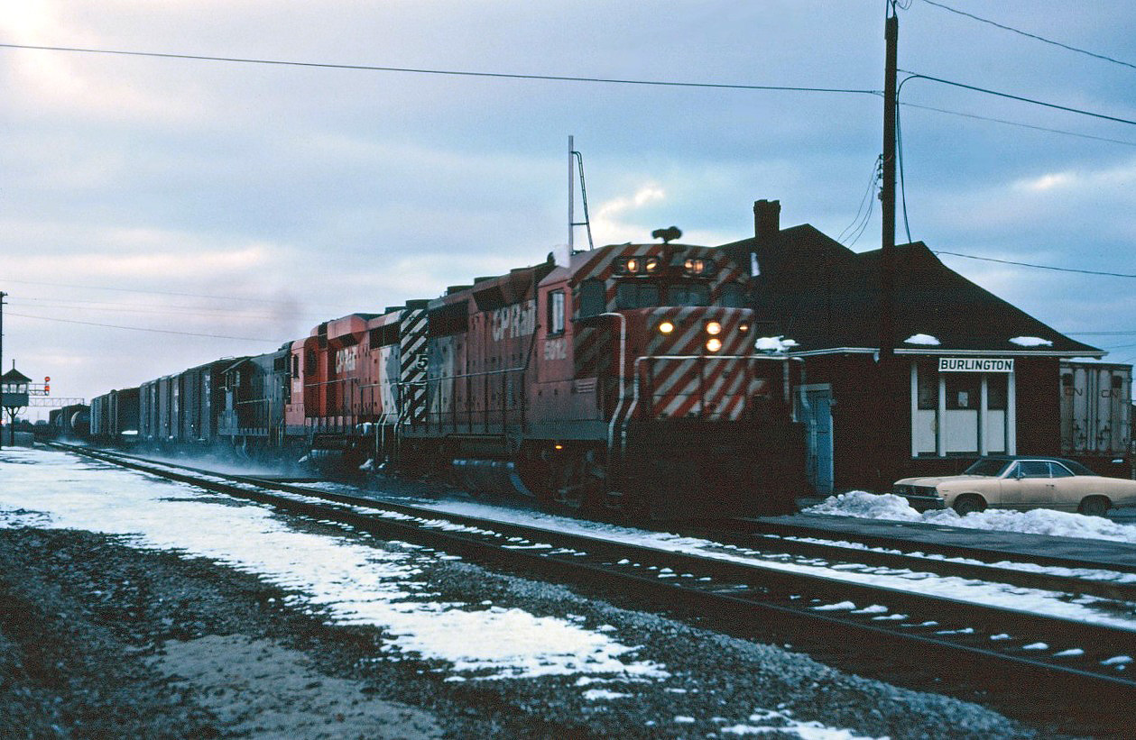As the late afternoon gloom descends, the "Starlight" makes its daily trip through Burlington on its way from CP's Toronto Yard ("Agincourt") to the TH&B's Aberdeen Yard in Hamilton. Note that the Brant Street crossing tower is still standing. Power is CP Rail GP35 5012, GP30 5000, and PC GP9 7431. Maybe after the train passes, we'll go into the station to warm up and see if Mercer's working this afternoon...