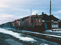 As the late afternoon gloom descends, the "Starlight" makes its daily trip through Burlington on its way from CP's Toronto Yard ("Agincourt") to the TH&B's Aberdeen Yard in Hamilton. Note that the Brant Street crossing tower is still standing. Power is CP Rail GP35 5012, GP30 5000, and PC GP9 7431. Maybe after the train passes, we'll go into the station to warm up and see if Mercer's working this afternoon...