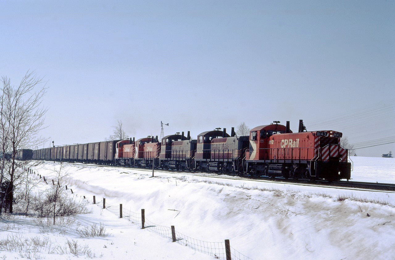 CP SW1200RS 8143 leads four other "pups" (8130, 8168, 8146, and 8147) out of Guelph Jct on a nice late winter day in 1971. Lash-ups like this were a fairly common sight on weekends when such units were gathered up and moved from branch line assignments to Toronto Yard for servicing.