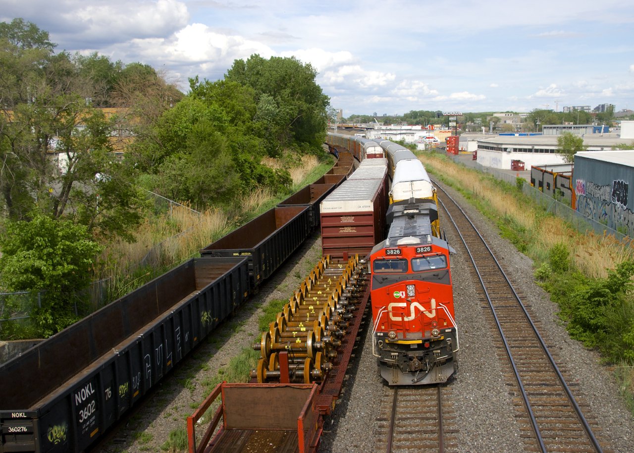 After setting off its cars for Joffre Yard in Taschereau Yard (they will go on CN 400 and were all located behind the DPU) CN 3826 brings up the rear of CN 322 as it heads to Southwark Yard where it will terminate. At left is a CN 306 which had been sitting there a couple of hours. Further to the left are stored gondolas.