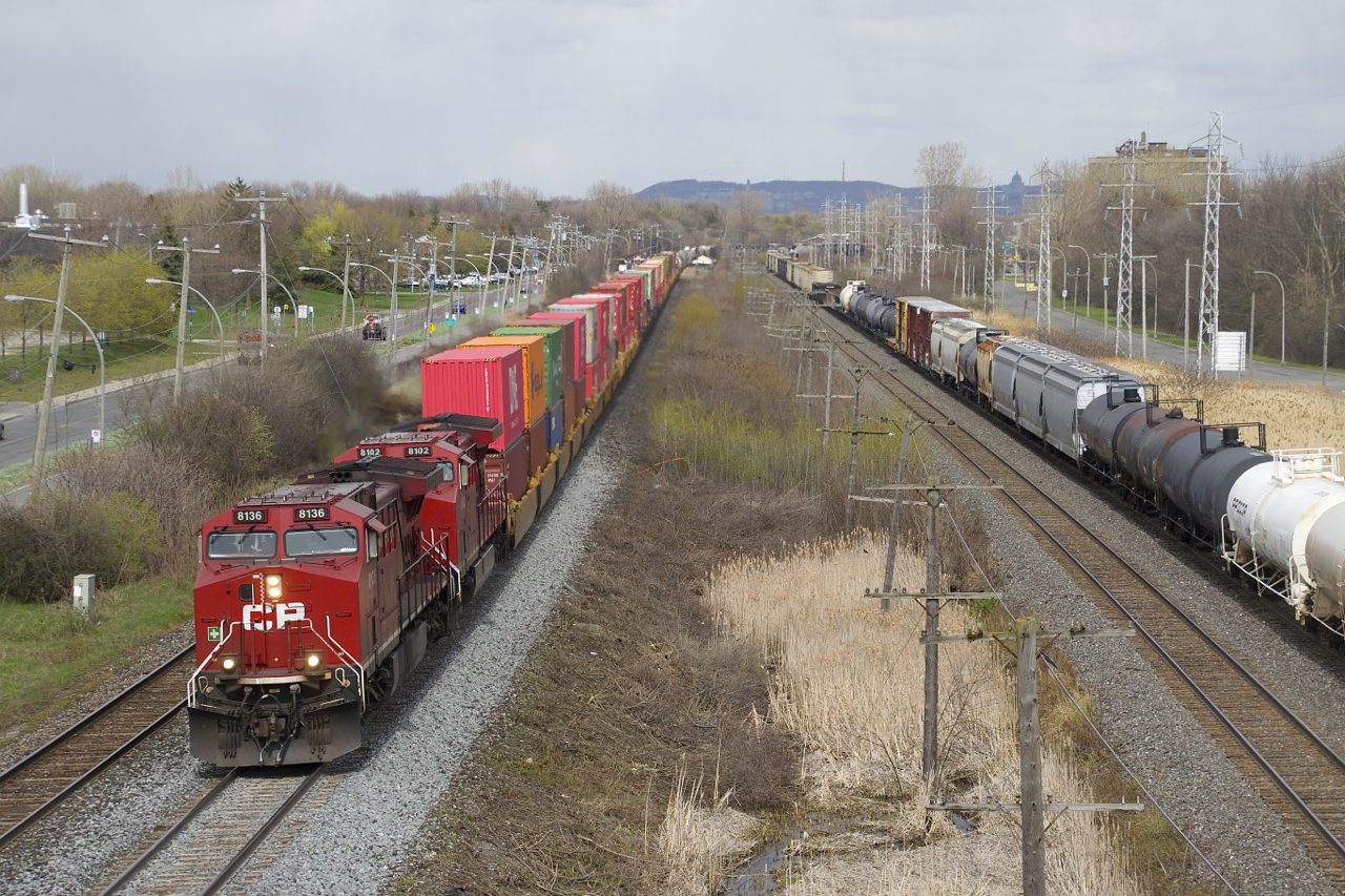 CP 119 is overtaking CN 377 as it heads west through Pointe-Claire with CP 8136 & CP 8102 up front and CP 8742 mid-train. It is passing over a section of freshly ballasted track.