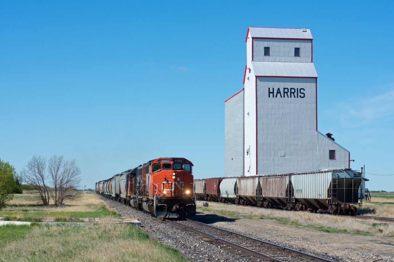 CN 5280 and 5367 lead train 540 past the one remanning elevator in Harris SK. Theres nothing to lift today though as the cars spotted at the elevator have yet to be loaded. The foundation for the old water tower is also visible in the lower left of this scene.