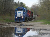 CN L568 is seen approaching Queen Street in Kitchener on the Huron Park Spur with GMTX 2264, 7068 and 4784 with cars for the interchange with Canadian Pacific. In all honesty, due to the overcast afternoon I was trying to find a location or side I wouldn’t normally photograph from on this spur due to the lack of sun. So I settled on this spot on the opposite side of where I normally photograph near the crossing and not even realizing the reflection of 568 in the large puddle in front of me until I eventually downloaded the photos. 