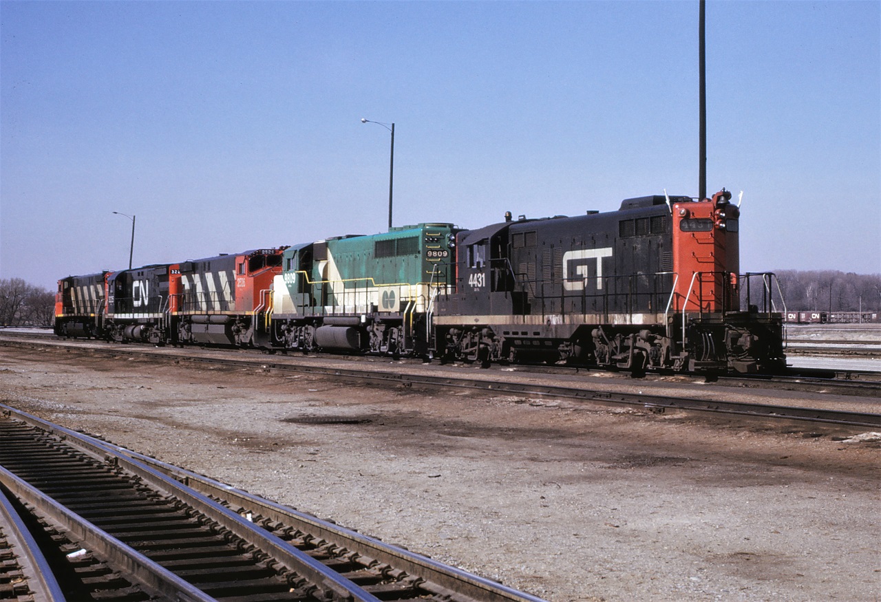 Variety!!!  The inbound motive power receiving tracks at the north end of Toronto Yard's diesel shop were always an interesting place back in the middle 1970s for you never knew what to expect.  Here is a good example and at that time all you had to do was sign a release, put on safety glasses, and a blue hard hat and the yard was yours to enjoy.  I was never into taking shots of lines of motive power, but I could not resist this combination.