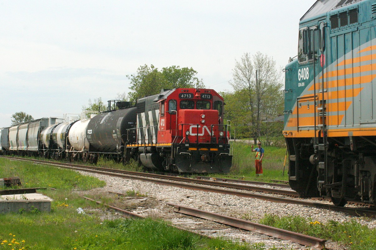 Throughout the Goderich-Exeter era on the Guelph Subdivision, train 516 from Stratford would regularly meet VIA Rail #85 in the small siding at Baden during the noon hour between switching customers between Baden and Stratford. However, after CN’s return in November 2018 there were no longer meets here during the afternoon as all the CN locals were now ordered out of Kitchener and L568 runs the same direction as 85. However, it should be noted that very occasionally L568 has met VIA Rail #87 here during the evenings on their return to Kitchener. 

However, a noon hour meet in Baden did occur at least once during 2019, as on one Friday morning CN L540 had to venture west to switch and lift a block of cars that had been previously set-off in the siding. Here, on a warm spring day, CN 4713 takes a break from switching and does a roll by inspection of 85 with 6408 west.