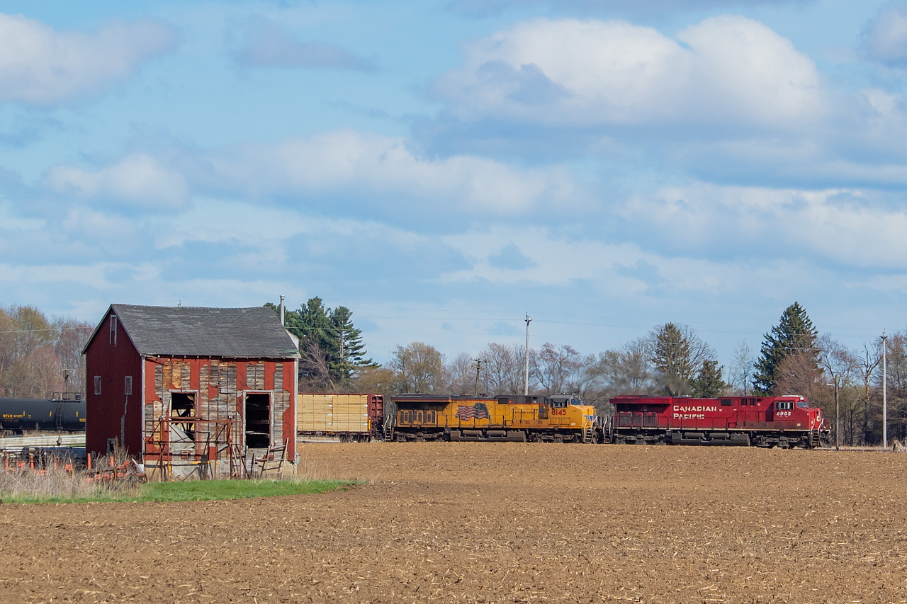 Having grown up in Norfolk County, Ontario's tobacco heartland (what a claim!), I have a certain affinity for tobacco kilns. Nothing says "home" quite like the sight of them. Picturing the old ROWs through Norfolk, passing through the tobacco fields and by tobacco kilns, I'd always imagined how cool it would have been to have gotten a shot of that. I hadn't even seen one that anyone got until a year or so ago when I saw a shot from Brian Thompson on Facebook of some Chessie power on the CASO going through La Salette past some kilns - easily one of my favourite shots of all time. When I was out shooting T29 the other weekend, I did some exploring, and found some old tobacco kilns in the area, and realized with some proper timing I'd be able to pull off a shot I'd long imagined. So with this 141 running around the right time, and the hourly forecast looking like it may work out, I decided to try my luck. It was pretty heavy cloud when the train departed London, but when it was about 5 or 10 minutes out from Bothwell, the sky finally cleared to my favour. As I heard it nearing, one cloud decided to cover the sun, and I knew it was going to be close. As the lights were going for the nearby crossing on Fansher Road, the cloud finally cleared, and with a few seconds to spare, I had sun on the scene. What a sigh of relief, as it's a long, depressing drive home if the clouds win out. These old kilns are largely being replaced with a newer, far less aesthetic structures, and less and less remain with many left to fall over (like this one no doubt soon will) or are simply burned (with a permit). Some farms around Norfolk take great pride in preserving their old kilns, simply from an aesthetic and heritage perspective, and for those farms I am grateful. The new ones that are now the norm are like the GEVOs of tobacco kilns, and truly lack any charm. If you asked me, I'd say the Windsor Sub is fairly underrated from an aesthetic point of view. It has many wide open angles, plenty of searchlights, and no shortage of interesting landmarks to incorporate into your shots. It is however a good trek for many of us, and with trains few and far between, and chasing near impossible, the return on investment for a trip to Ontario's far south can sometimes be just one shot - as it was for me on this day.