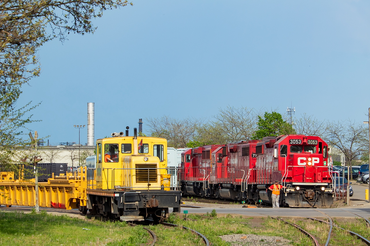 The crew of CP TH11 watches as one of the two NSC critters shoves a cut of cars back into the plant property. It felt like mid-July with humidex values well into the high 30s, and as is normal on a hot summer day some storms started to pop up. At the time, the skies to the north and east and started to cloud over and faint rumbles of thunder could be heard in the distance. Luckily for me though, the skies to the west were clear and sunny, which is what mattered most for the shot.