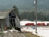 An eastbound grain empties heads downgrade from Notch Hill Summit passing a derelict bar. Notch hill is ridge between Salmon Arm and Chase between the two arms of the U shaped Shuswap Lake