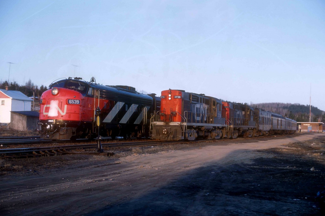 Tuesday, April 29, 1969, saw my friend Ken McCutcheon and I on hand to see CN Train 70 arrive at 5.30 a.m. in Chambord, Quebec, from Montreal.   

At the time, business was brisk on the daily service, and CN offered a range of accommodations on the train from coach seats to a drawing-room.  I did not record the consist of Train 70 as it departed at 5.50 for the last 51.3 miles of its 317.8-mile, 13-hour trip to Chicoutimi, but the trailing car was Manitou.  Departing CN FP9 6539 led an F9B with four baggage cars, two coaches, a buffet lounge and sleeping car 1700, WINDIGO.  In 1954, Pullman Standard built 4 section, 4 roomette, 1 compartment, 5 double bedroom lightweight sleeper for the Florida East Coast.  Originally named SCOTT M. LOFTIN for a U.S. Senator (D) and FEC trustee from Florida, it became the NASSAU for the FEC, who sold it to CN in January 1967.   VIA acquired the car in March 1978 and retired it forty-eight months later.  Herron Rail Services in Tampa, Florida, bought it in January 1983.  The previous morning we had seen its similar configured running-mate MANITOU, formerly FEC's JAMAICA.  For many years the pair ran on the NORTHLAND from Toronto to Kapuskasing.      

The FP9 operates today as Ontario Southland 1400.  After serving CN since June 1958 (serial #A1399), it ran as VIA 6539 from April 1978 through February 1984.  VIA had CN rebuilt it with a 16 cylinder 645C GM prime mover, and it returned as 6303.   With no steam generator, VIA assigned it to Winnipeg for use on trains to Churchill.  It was sold to RailAmerica, going to the Mackenzie Northern in Alberta as Railink 1400 in 1998 and then to the Goderich and Exeter in Ontario in September 2003.  It went to Ontario Southland in August 2012.    

Connecting Train 183 for the three hour and fifteen-minute run to Dolbeau, 57.4 miles away on the far side of Lac St. Jean, included a steam generator unit, two baggage cars, a coach and through sleeping car WAINWRIGHT.   The car built by Canadian Car & Foundry in the fall of 1923 was a heavyweight 12 section, 1 drawing-room car.  CN installed ice air conditioning with a roof-mounted duct in 1939 and rebuilt the car as an 8-1-2 in February 1949 by replacing 4 sections with 2 compartments.  It became CN work car 54959 in January 1980, and CN scrapped it in December 1992.  

At 6.05 a.m., Train 183 would also pull east from the Chambord station but then take traverse the west leg of the wye and exit the tail track heading straight for Dolbeau on the Roberval sub.  A pair of MLW RS-18s, 3736 and 3684, powered the departing train.  3736 (MLW 1958, 82499) ran the 29.5 miles to St. Felicien, where the crew set it off for local service and continued with the 3684 alone.  CN retired 3736 on Thursday, December 8, 1988.  CN sold it for scrap to Sidbec Feruni in March 1991; it vanished in their steel mill in Contrecoeur, Quebec.  January 1958-built MLW (#82226) 3684 went to Exporail in St-Constant, Quebec, in 1993 as an operating example of the 352 RS-18s.  It well represents MLW's all-time most successful diesel model.