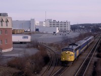 Moncton bound Via Train 613 is about to scoot under the overpass on Mumford Road in Halifax, Nova Scotia.  It had just left the Armdale station in the background at 5.25 p.m. in late March 1989.  At the time, Acadian [bus] Lines was on strike so VIA allocated the customarily assigned RDC's to augment their Yarmouth and Sydney services.  The trailing RDC would be cutoff in Truro and continue to Port Hawkesbury, Nova Scotia as Train 606.  VIA employed conventional equipment on the Moncton route powered by GMD and MLW cab units.  The FPA-4s ended their service at the end of the month as they were not retrofitted with Reset Safety Control as mandated by Canada's National Transportation Agency. <br> <br>    CNR 6505 (GMDL 11-1954 #A-635) was part of the railway's initial order for passenger units, 28 A-B pairs in early 1954.  It became VIA 6505 on Friday, March 31, 1978.  Later, VIA sold it on Wednesday, March 8, 1995, for use on the Conway Scenic Railway.  Pan Am Railways bought the unit for its executive train and renumbered it PAR 1. <br> <br>Much has vanished from this scene in the last thirty years.  The rail-served Sears distribution centre has become a Walmart on the lower level and a Sobeys supermarket on the upper level of the West End Mall.  Sears, formerly, the Simpsons store in the background, has been transformed into an office complex while Sears has withdrawn from retailing throughout Canada.  The Sears siding formerly gave access to the Scotia Railroad Museum just to the left of the fencing.  Also, CN removed the inbound double main track in the 1990s.   With all the changes around the city, the vantage point remains one of only a handful in Halifax, where one may easily get a photograph of an entire passenger train coming and going.  