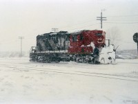 Working on the railway happens in all weather - the man in 4377's stairwell is getting the worst of it.<br>
John Parnell was out in this January snowstorm with his camera.<br><br>
GP9 CN 4377 was remanufactured into GP9rm CN 7080 in 1993 by AMF (the former CN Pointe-St-Charles shops), according to the 1994 Canadian Trackside Guide.