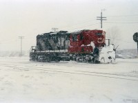 Working on the railway happens in all weather - the man in 4377's stairwell is getting the worst of it.<br>
John Parnell was out in this January snowstorm with his camera.<br><br>
GP9 CN 4377 was remanufactured into GP9rm CN 7080 in 1993 by AMF (the former CN Pointe-St-Charles shops), according to the 1994 Canadian Trackside Guide.