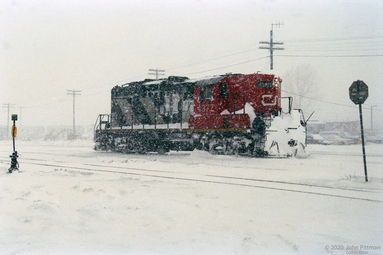 Working on the railway happens in all weather - the man in 4377's stairwell is getting the worst of it.
John Parnell was out in this January snowstorm with his camera.
GP9 CN 4377 was remanufactured into GP9rm CN 7080 in 1993 by AMF (the former CN Pointe-St-Charles shops), according to the 1994 Canadian Trackside Guide.