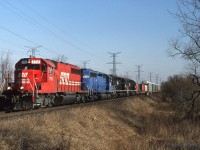  CP 511-17 cruises down the "Hornby Dip" at the 6th Line crossing just East Of Milton, Ont with a colourful power consist during the rainbow/rent-a-wreck era. Feb 17th 1995.  