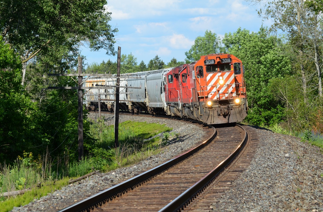 A short train of interchange traffic from the GJR at Campbellville rounds the bend at Concession 14 east of Puslinch Siding doing nothing but track speed with original painted 3018 in lead. The good old CP situation brings sun for 1 minute, then clouds for 5 minutes and on and on and on yeah you get it. Thankfully, they were cleared to B/E CTC Sign Ayr from Gue Jct as the thick clouds broke apart so it was very ideal for my first time seeing this lead since the start of it’s assignment in London. The “action red” paint as well as the stripes on 3018 is a fantastic change to the usual CP paint schemes you see out of London for this job and knowing it was facing west and will lead the correct way at the correct time of day for light, I had to finally put the effort in to shoot this job again