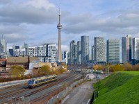 A westbound UP Express train leaves the USRC behind dropping downgrade to pass beneath Strachan Avenue as it heads towards it's few stops on the way to Pearson International.  In the background a westbound GO train heads onto the Oakville Sub.