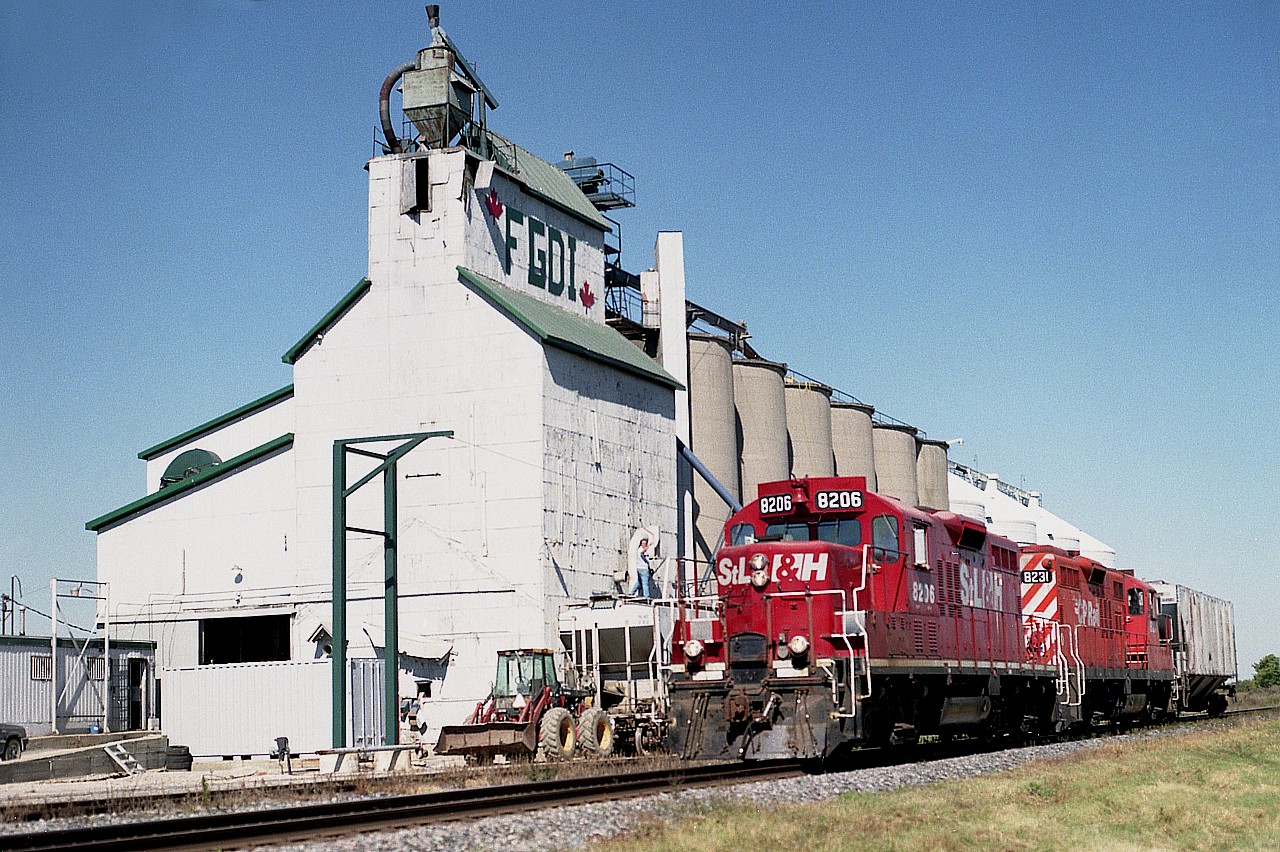 Okay....so this place is Arkwood, is it? I appreciate that information because I didn't know and put down Louisville, which I guess is slightly farther south-east.
Seeing some RP contributors getting credit for shooting here, I thought I had better add my name, indirectly, to the list. :o) Westbound with one car is STLH 8206 and CP 8231. The sidekick of the day, after some coaching, pulled off this not-too-bad a shot, while I elected to get close in on the action. We expected a mainline freight, you know, like a couple of SOOs up front or something. Wishful thinking I guess. And so I elected to try a "down the line" shot, and I get rewarded with this little puddle-jumper.  Got a wave from a friendly engineer though; you can see me up on top of the hopper.:o)