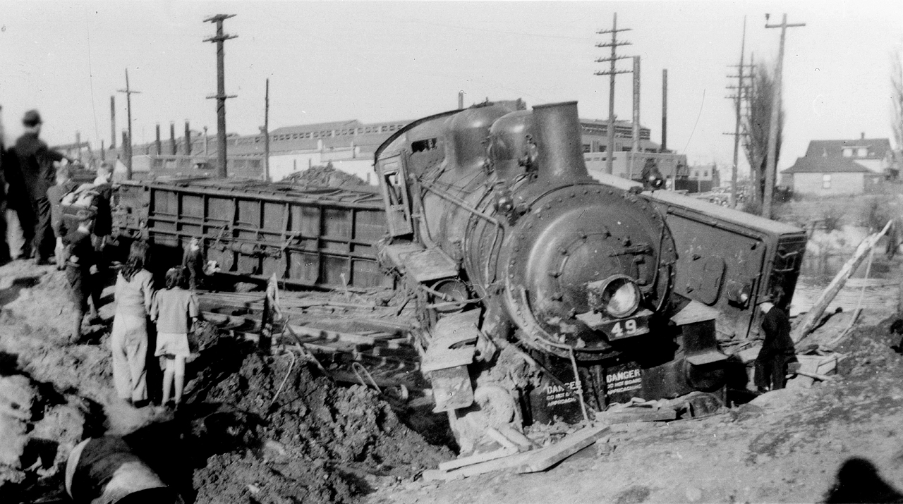 April 27, 1944 finds TH&B 0-6-0 49, built by CLC Kingston, 1918, returning to Kinnear Yard after working on the Belt Line.  On the return trip the train struck a truck at the Beach Road crossing, just west of Ottawa Street and immediately north of the CNR Grimsby Sub overpass.  The resulting derailment caused the locomotive to tear up the ground, striking a propane gas line, and causing a flash explosion with flames reported in excess of 40 feet.  The engineer, Clarence Kappler, received fatal injuries pinned between the locomotive and tender.TH&B 49 would continue in TH&B service until 1950, when it was sold to Dominion Foundries & Steel for switching duties.  Other photos from this day show the crowds surrounding the scene, both at TH&B level and above on the Grimsby Sub, watching a TH&B crane arrive on scene to clear the mess.  The crane came from Hamilton's north end.  Kept down at Adam's Yard?  The only TH&B cranes seen on this site are X-755 (Built 1952 - American Hoist & Derrick - 30 ton capacity) and X766 (Built 1954 - Industrial Brownhoist - 250 ton capacity).