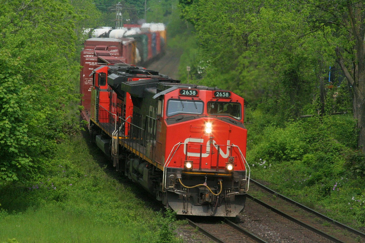 CN 2658 is leading an eastbound as it curves through Paris, Ontario on the Dundas Subdivision seen from the John Street bridge. This is still a great location for eastbound photos, however the vegetation has grown in considerably over the years.