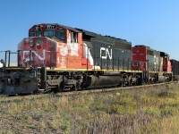 The eastbound they were waiting for has now passed. Next is to have the route lined up plus a light to proceed and the 5277 with a train of open top hoppers will leave Clover Bar behind. 