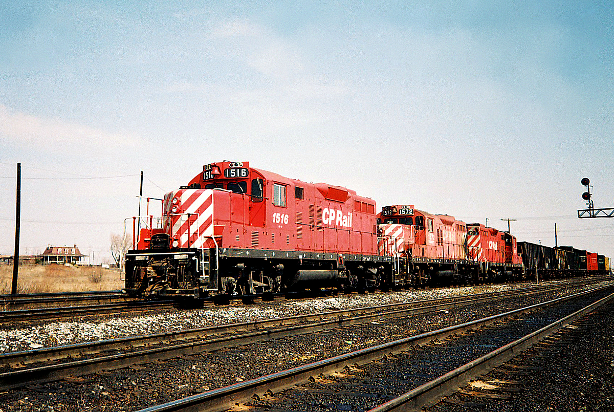 A trio of Canadian Pacific GP9u's 1516, 1572 and 1519 are viewed pulling out another cut of cars that will be humped at Toronto Yard on a spring morning. This trio of yard goats were the regular assigned hump power at the time, along with other sets of GP7u's and GP9u's.