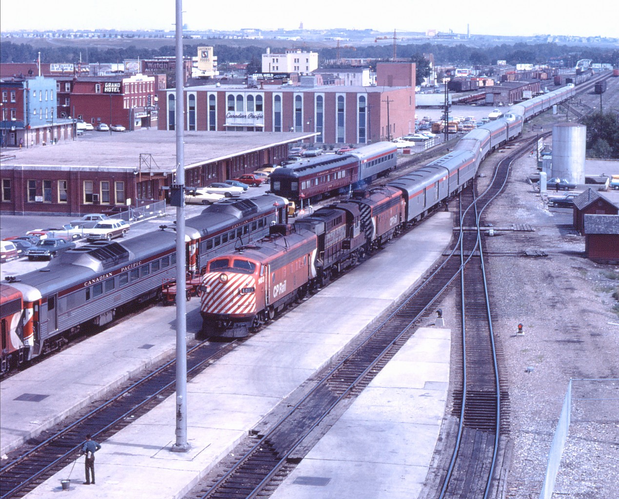 "CP Rail Train No. 1, The Canadian, is now arriving from `Regina, Winnipeg, Thunder Bay, Sudbury, Toronto and Montreal". If on time, No. 1 arrived in Calgary at 1305 and would depart at 1340, with ultimate arrival in Vancouver at 1010 the next morning. (Eastbound, The Canadian had a scheduled 1435 arrival and 1510 departure in the summer of 1971.) This timing permitted connections with train numbers 302 (departing Edmonton at 0830 and arriving Calgary at 1210), 301 (departing Calgary at 1600 for Edmonton, arriving at 1940), 310/312 for Lethbridge (departing at 1610 and arriving at 1850; 3 days/week via Fort McLeod and 4 days/week via Coalhurst), and 309/311 departing Lethbridge at 1000 and arriving Calgary at 1240 (also 3 days/week via Fort McLeod and 4 days/week via Coalhurst)--note the two Budd RDCs to the north of the inbound train. FP7 1403 leads a steam generator equipped RS10 and another FP7 with a "summer" sized consist. I'm sure everyone looking at this photo would love to race down to the station concourse to buy a ticket for the West Coast if we could!