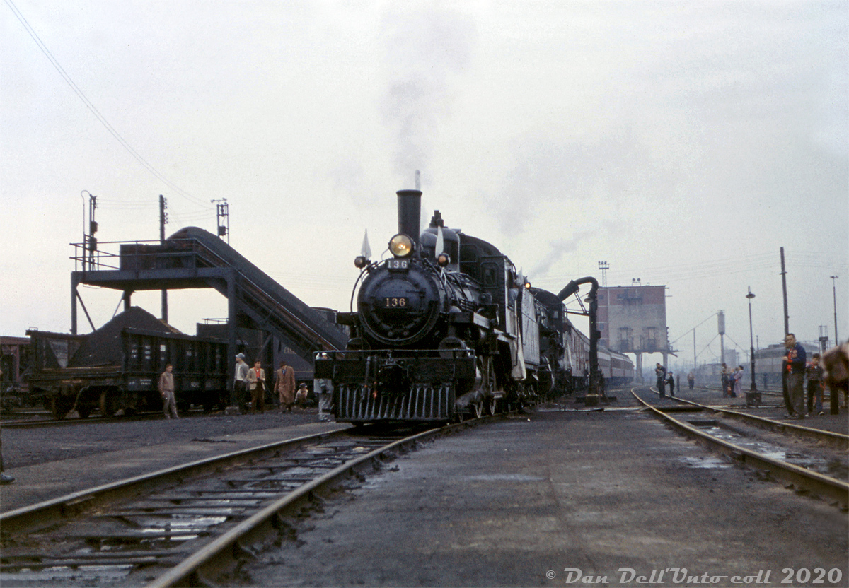 Prior to the famed CPR Tripleheader fantrip of Sunday May 1st 1960, a doubleheader was run on the Saturday before (April 30th) on the Galt Sub, from Toronto to Cooksville and back (fully within yard limits) with just 4-4-0 136 and D10 4-6-0 815. The pair are pictured here with their train, sitting over the ash pit at Lambton Roundhouse in Toronto as fantrip attendees stretch their legs and get some photos in. The Alco/MLW FA's on the ready tracks nearby hint that the first few months of 1960 were the final hurrah for Canadian steam in regular operation, and Lambton roundhouse itself would be made redundant by the diesel and demolished months later in October 1960. The coal tower in the distance would be pulled down by diesel switchers a few years later.

According to Ray Kennedy (the organizer of this fantrip and the subsequent one) the consist on this day was round roof baggage 4329, two steel coaches, two wooden coaches, and wooden combine-baggage 3262 (previously used on branchline mixed trains, and specially brought to Toronto).

On the left, a conveyor transports ash (dumped out of steam locomotive fireboxes) from the ash pit into a CP 369000-series Hart convertible gondola spotted on the adjacent track. This car type was popular in the steam era for hauling ballast, fill, and other materials. Often, a Lidgerwood winch car would be used to pull a plow through the insides of the cars in order to "dump" (push) the ballast out the sides. Conventional bottom-dumping ballast hoppers and air-operated side dumps replaced them for the most part.

Original photographer unknown, Dan Dell'Unto collection slide.