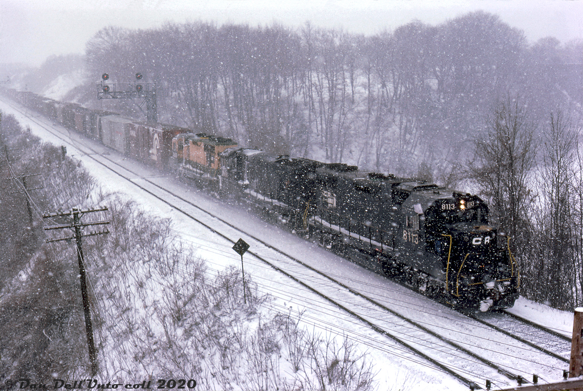 Rain or shine, sun or snow: on this snowy winter's day, Reg Button was out to capture a photo of Conrail train FT-1 (Frontier-Toronto) heading eastbound through Bayview Junction on CN's Oakville Sub, bound for CP trackage at Canpa and on to Toronto (Agincourt) Yard. Power today is Conrail GP38 8113, U33B 2906 (both in patched Penn Central paint), and GP35 3628 (patched but still in former owner Reading's colours). While visibility was less than ideal, the latter unit probably made braving the cold and wintry elements worth it.

Reg Button photo, Dan Dell'Unto collection slide.
