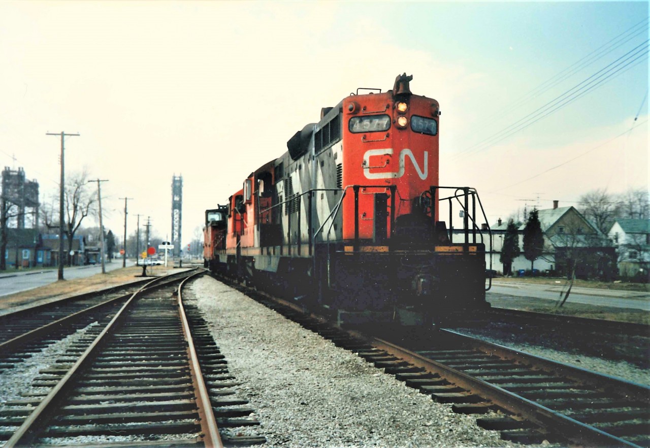 No White Christmas in site here as we have a snow less Christmas eve in 1986 with two GEEP's waiting to cross the Welland Canal.  They have just completed a series of lumber car drops in the former Canadian Furnace yard along the east side of the Welland Canal for Sherk Lumber (a firm that dates back to the early 1800's and is still in business as a Timber Mart).  The lumber would be shipped by barge to the United States.  The CN NICKEL sign is barely visible below the crossing lights on the left and the Bridge 20 Signal #189 controlled by the St. Lawrence Seaway can be seen just to the right of the railway lift bridge.  Canal traffic normally runs mid-March to early January so these would be the last ships to clear the system before the winter tie up.
