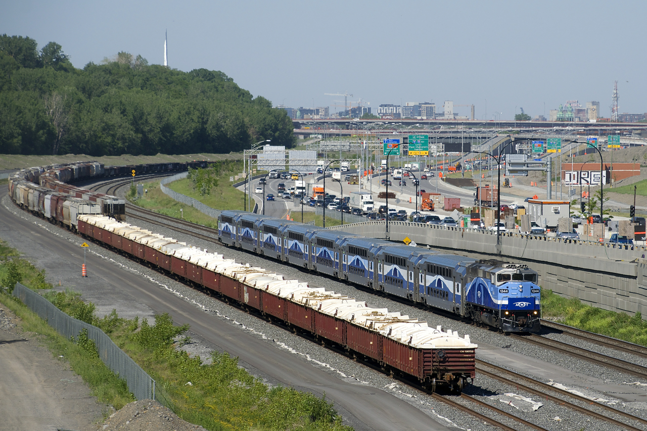 AMT 1344 leads EXO 1207 past cars which are stored on both track 29 and the freight track of CN's Montreal Sub. At the right in the background is the newly rebuilt (and not quite finished) Turcot interchange. Nearly all of this space was part of CN's Turcot Yard, which closed in 2002.