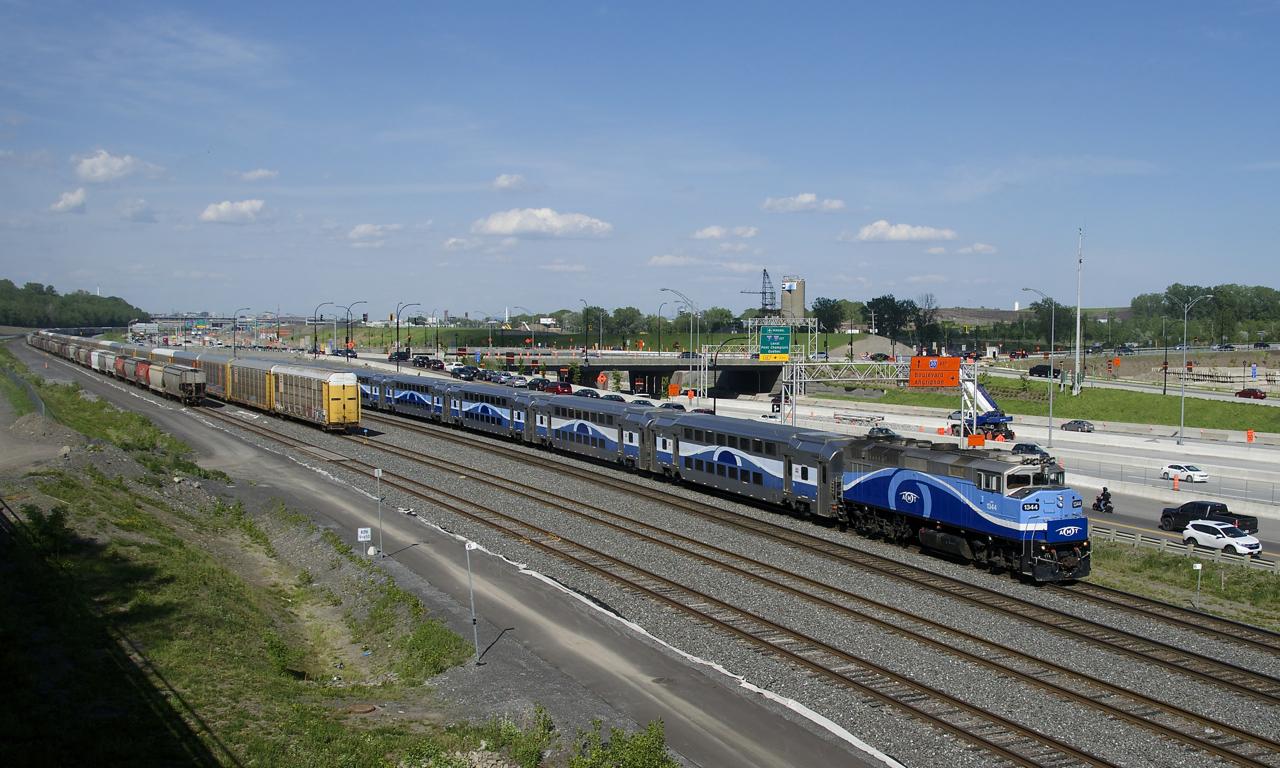 AMT 1344 leads EXO 1207 past autoracks and grain cars which are on the freight track and track 29 of CN's Montreal Sub respectively as it approaches Turcot Ouest.