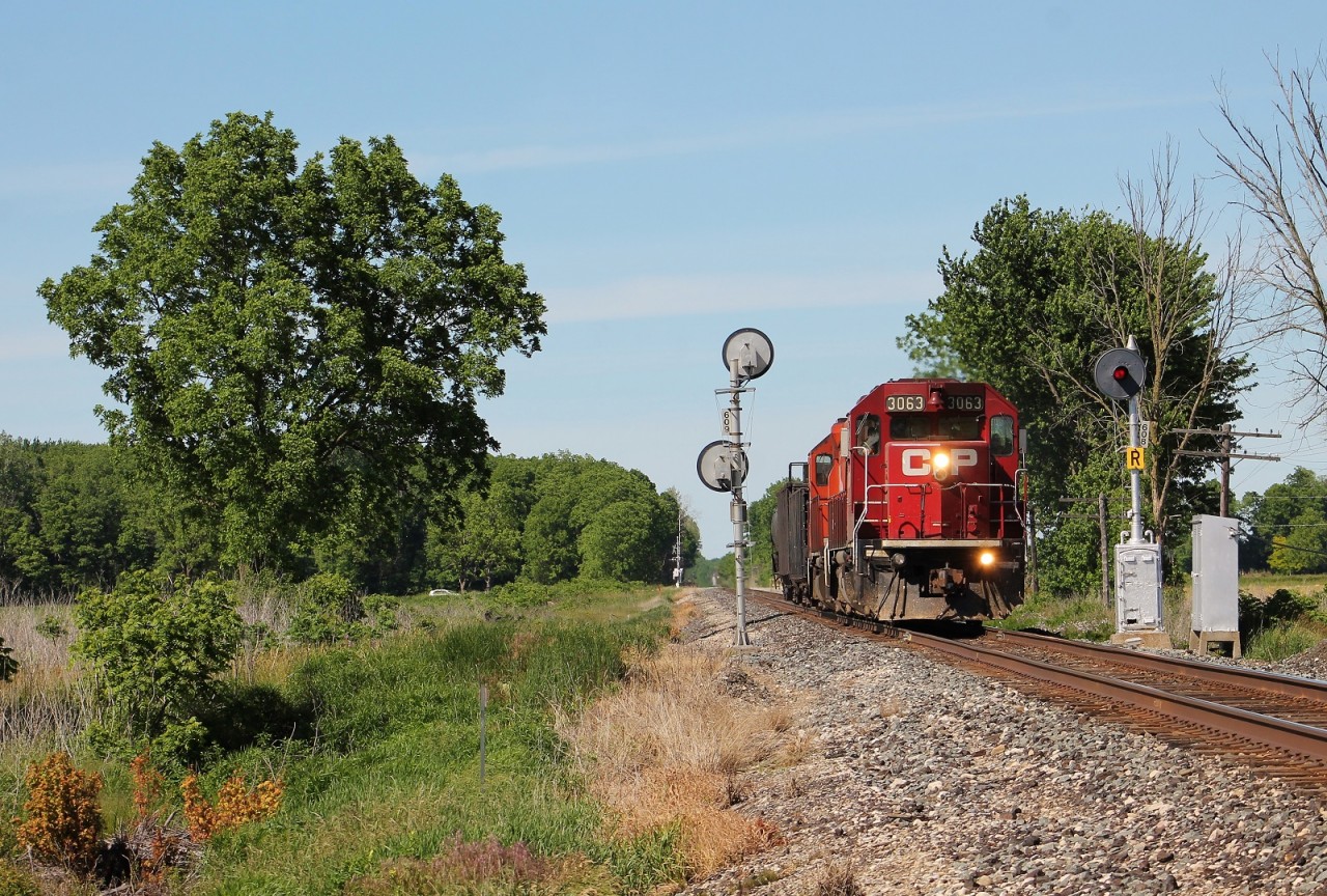 The Chatham Turn splits the intermediates east of town on a muggy spring afternoon. This relay mounted searchlight is likely one of the oldest signals still in use on this line. They have two gondolas that will be loaded with old ties in Chatham Yard and a single tank car for the ethanol plant in town.
