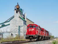 A trio of GP38-2s provides the power for the day's T29 as it blasts past the old elevator in Arkwood, doing a healthy 60 mph. This elevator is hard to find history on, but from what I can tell, it last operated in 2013. The letters at the top, FGDI, stand for Farmers Grain Dealers Inc., though the elevator passed through several owners in its life including Taylor Grain. There were three tracks here - the main, a siding, and the track that serviced the elevator itself. As you can see the siding is cut off, but it still has two derails on it. The tracks up to the elevator are still there but are slowly being buried over time. And the switch to that track to the elevator is still in place off the siding. Way off in the distance you can see the still active elevator in <a href="http://www.railpictures.ca/?attachment_id=41591" target="_blank">Kent Bridge</a>. <br><br> Other RP contributors have posted shots here in the past, including <a href="http://www.railpictures.ca/?attachment_id=10685" target="_blank">Hunter Holmes</a>, <a href="http://www.railpictures.ca/?attachment_id=3545" target="_blank">Jay Butler</a>, and <a href="http://www.railpictures.ca/?attachment_id=41525" target="_blank">Mike Molnar</a>. On this particular day, T29 had one tank for the ethanol plant in Chatham. They'd leave the tank on the main at Ringold, run around it, and tie back on before working the plant then heading back home to London.