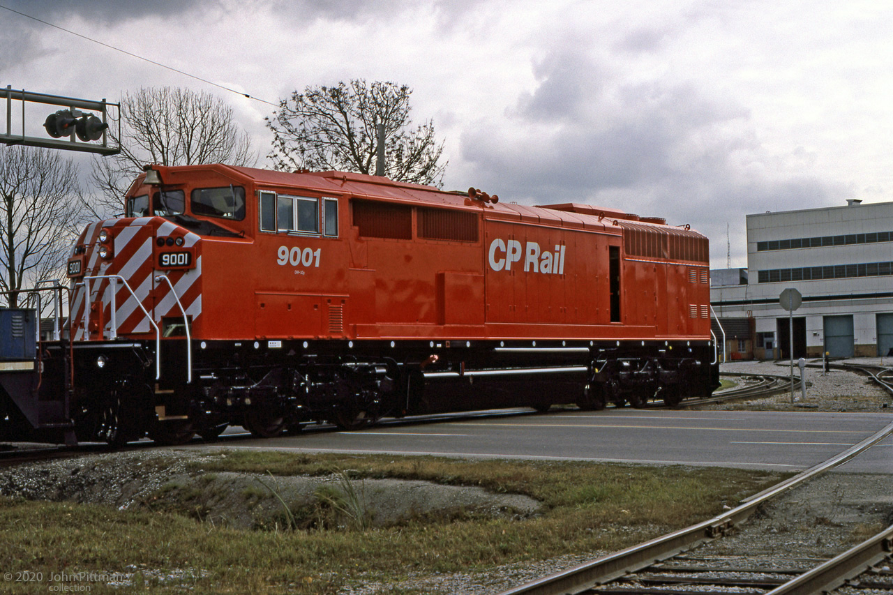 Inspired by recent pictures of CM&Q SD40-2F in Ontario, here is one that goes back to their first weeks.
Gord Taylor caught 2nd unit CP 9001 crossing Oxford Street East just outside the north end of the GMDD plant.
It appears to me that the engine ahead is a GMDD plant switcher, moving CP 9001 around the plant pre-delivery.
CP 9000 and 9001 were added to the CP roster 3 weeks after this picture.
This batch of 25 SD40-2F could have lead to more orders, if they had been as satisfactory as CP's SD40-2 fleet. 
However there were serious initial defects, especially with the EMD 645 diesel engines, so that all SD40-2F's had to be returned and reworked after delivery.  
The cowl body configuration also tended to be unpopular with operating crews.