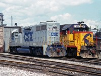 Tail and head end of two CSX EMD GP38 units at the CSX locomotive facility in Sarnia.<br>Both originally built for the Baltimore & Ohio Railroad, as BO 3801 and BO 3802.<br>Numbered by B&O for their EMD model, their CSX number series matches their 2000 horsepower.<br><br>CSXT 2002 in Chessie System colours has a unique title:  Trains Magazine's "All American Diesel" 1982<br>It wears this identification on the box ahead of the cab-side unit number.<br>BO 3801 was in the B&O blue scheme in 1985, so it likely wore those colours into the CSXT merger.