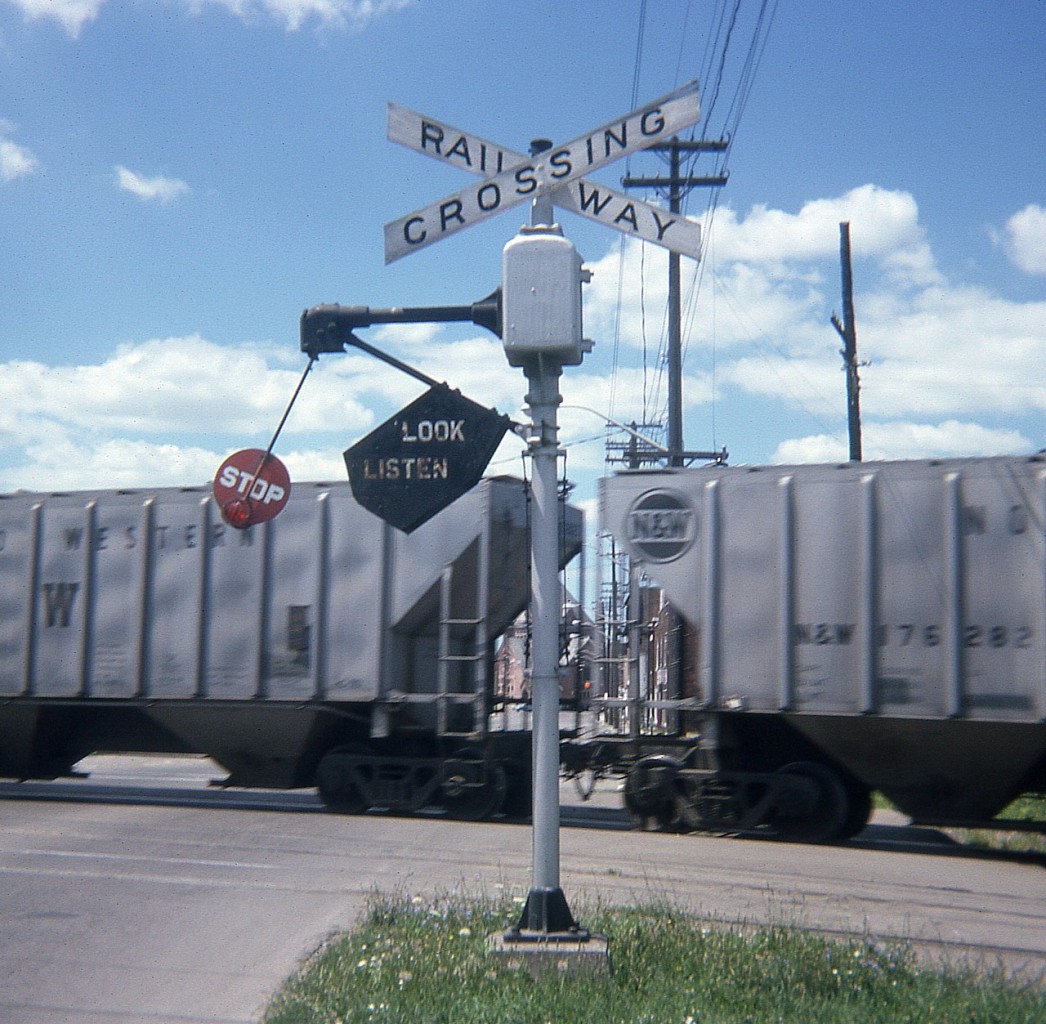 For the history buffs I dug this one up.  I don't even know what town it was shot at because I did not mark the old square slide. But it MIGHT be St. Thomas.
These neat looking signals were on the way out by the time I got to shooting this. I remember one at Biggar Rd in Niagara that hung on for a long time, plus a couple of others along the way.
They're all gone now, just like wayside shanties and phone boxes. So this RP offering is for those have never seen and old "Stop, Look & Listen" wig-wag.