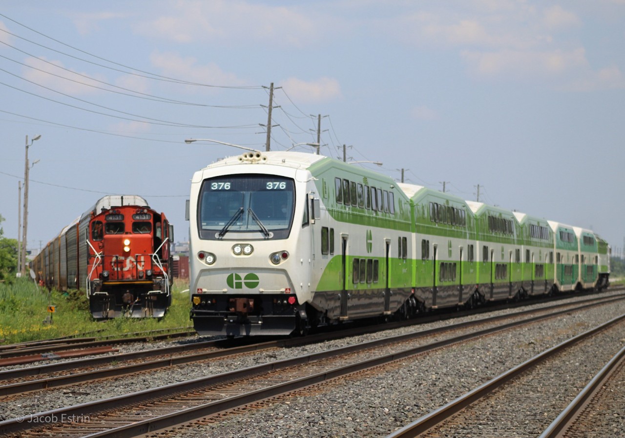 Two trains in one shot, to the hourly Lakeshore West train and to the right we have CN 4131 backing a string of autoracks into the Ford plant.