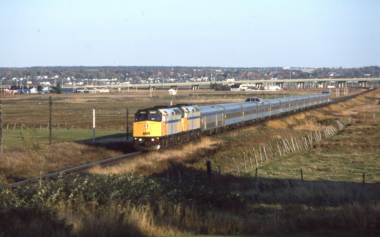 On Thursday, October 13, 1994, I began a drive from Halifax to Ottawa.  I chased VIA's ATLANTIC as far as Moncton, New Brunswick.  This image shows it nearing Fort Lawrence, less than a mile from the New Brunswick border.  The town of Amherst, Nova Scotia is in the background of this view near Mileage 79.5 of CN's Springhill Subdivision. 

The tri-weekly ATLANTIC would only travel via Saint John, N.B. on its way to Montreal for just over two more months.  It would then be replaced by three additional round trips of the OCEAN via Campbellton.   This day it's consist included F40PH-2s 6427 6435 baggage 8621 coaches 8139 8146 Skyline 8511 coach 8147 diner ACADIAN Chateau sleepers PAPINEAU BRULE MONTCALM MAISONNEUVE DENONVILLE CLOSSE DOLLARD and dome lounge sleeper REVELSTOKE PARK.