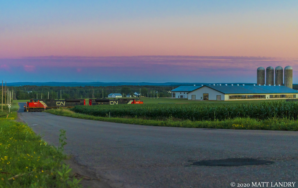 A pair of SD70M-2's lead train 406 along the farmers fields at Boundary Creek, New Brunswick at sunset. A perfect shot to show what southern New Brunswick is like.