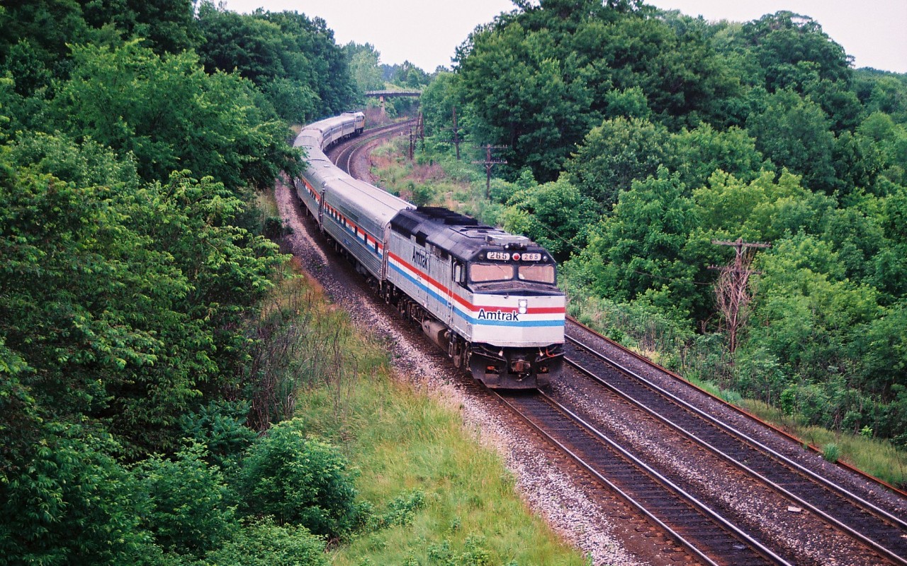 A westbound Amtrak train on the Oakville Subdivision in the evening....it apparently happened once a week for a brief time. Here the short-lived Amtrak "Niagara Rainbow" is seen approaching the Plains Road bridge and Bayview Junction with dead-heading VIA Rail equipment with Amtrak 265 leading to New York. According to a Canadian Rail magazine article from 1996 that has a great detailed history of Amtrak operations in Canada, this train was named as a throwback to the original "Niagara Rainbow" that operated from New York to Detroit via St. Thomas. The 1994 version ran on an overnight schedule from New York City to Toronto northbound. Train 65 departed New York on Fridays only, while southbound 62 departed from Toronto only on Sundays as seen here.

According to the article written by Fred F. Angus, the trains were to have started operations on May 1 1994 and run twice weekly in both directions. However they were delayed until June 1994 and only operated once weekly. Reportedly, this was the only Amtrak service into Canada that did not run on a daily schedule. On September 10, 1995 the "Niagara Rainbow" train service would be discontinued and fade quietly into history once again.