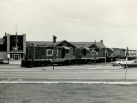On detour due to the <a href=http://www.railpictures.ca/?attachment_id=37625>Nash Road Wreck</a> which occurred on <a href=http://www.railpictures.ca/?attachment_id=37624>July 5, 1968</a>, CN 466 traverses the Beach Sub crossing Lakeshore Road in Burlington with CN 4479, 4487, 3239 for power.  The train is seen passing the <a href=https://www.dancescape.com/brantinnhistory>Brant Inn</a>, fondly remembered by many for the famous bands and dances hosted there.<br><br>The original Brant Hotel and Country Club, built in 1900 where the Joseph Brant Memorial Hospital now stands, served as a hotel and club until 1917, when the hotel was expropriated by the Canadian government for use as a military hospital.  The Country Club was renovated into the Brant Inn, continuing as such until a fire on the roof (possibly started by cinders from a passing train) in 1925 burnt the place to the ground.  This second Brant Inn was constructed between 1925-1926 and opened as pictured above, and would be managed by John Murray Anderson through it's peak years with many famous headliners.  Performers included Bert Niosi & Orchestra, Frankie Laine, Sophie Tucker, Louis Armstrong, Ella Fitzgerald, Guy Lombardo, Johnny Mathis, and Liberace.  As the 'Big Band Dances' died out with the times, so too did the Brant Inn.  With health deteriorating, Anderson sold the inn to International Atlas Development and Exploration Ltd. in 1964.  Attempts to keep the place popular continued until 1968, when the company decided to close and demolish the Brant Inn.  The final event would be held on New Years Eve, 1968; demolition began early 1969.  Today this site is home to Spencer Smith Park, named after the former Burlington Horticultural Society president.  The park includes various memorials; to Terry Fox, the Royal Canadian Naval Association Naval Memorial, and a plaque dedicated to the Brant Inn.<br><br>Locomotive-wise, both GP9's came out of GMD London in 1956.  Leader 4479 would be rebuilt in 1985 to CN 7002 and retired in 2000, finally being sold in 2003 to Pioneer RailCorp retaining it's number.  Trailing geep 4487 would be rebuilt in 1992 to 7048 and continued in CN service until retirement in 2007.  It would be sold in 2014 to the Carolina Costal Railway in North Carolina as their 7048.  MLW C-424 3239, built 1967, would be retired, along with the rest of the fleet, in the mid 1980's.